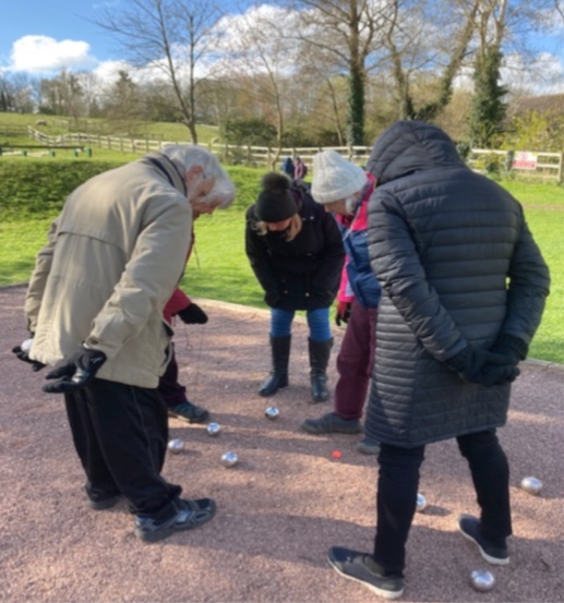 An image of a group of people playing pétanque