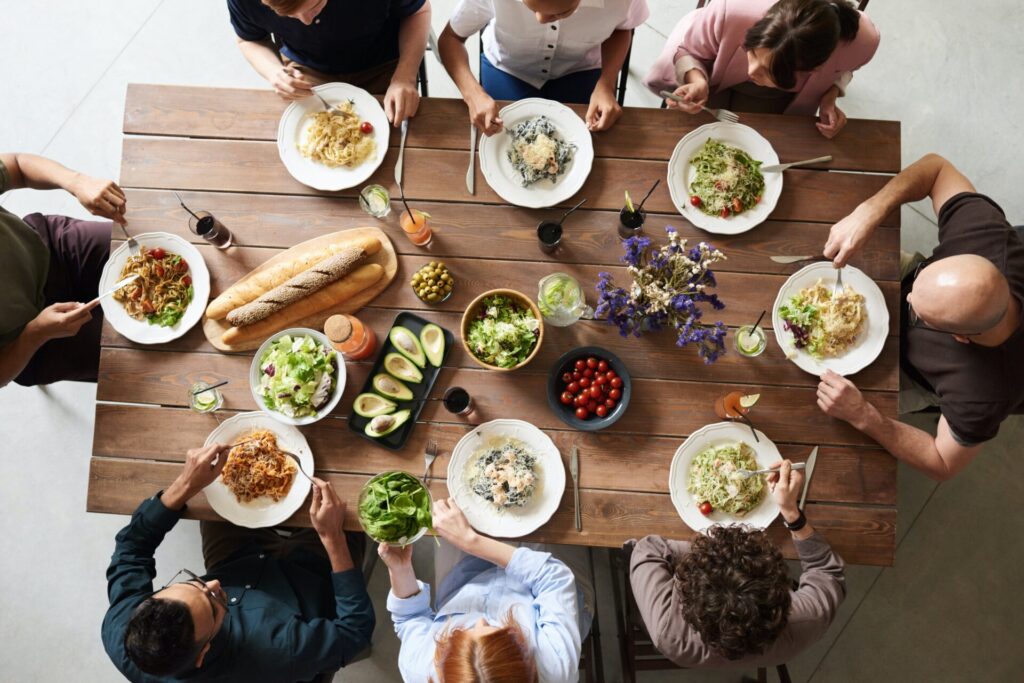 an image of people eating a meal at a wooden table